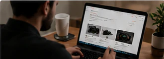Person comparing used cameras on a laptop